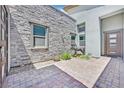 Paver walkway to the front door with horse statue, stone facade, and gray trim windows at 6184 Willow Rock St, Las Vegas, NV 89135