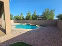 Sparkling backyard swimming pool with a rock border and gravel landscaping at 7380 Abundant Harvest Ave, Las Vegas, NV 89131