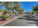 Gated entrance to the community with decorative metal gates and stone pillars at 7380 Abundant Harvest Ave, Las Vegas, NV 89131