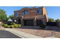 Two story home with a two car garage, landscaped yard, and brick driveway at 7380 Abundant Harvest Ave, Las Vegas, NV 89131