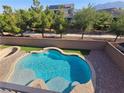 Backyard swimming pool with tanning deck and surrounded by lush landscaping at 7380 Abundant Harvest Ave, Las Vegas, NV 89131