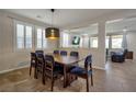 Inviting dining room with a modern light fixture, shutters, and a view to the living room at 7520 Fontera Ct, Las Vegas, NV 89139