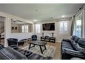 Open-concept living room featuring neutral walls, shutters, a large TV, and stylish furniture at 7520 Fontera Ct, Las Vegas, NV 89139