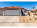 Attractive single-story home with a red tiled roof, a two-car garage, and low-maintenance landscaping at 7728 Barbican Ct, Las Vegas, NV 89147