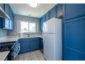 Functional kitchen featuring blue cabinets, white countertops, a gas range, and modern appliances at 7728 Barbican Ct, Las Vegas, NV 89147