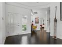 Bright entryway featuring dark hardwood floors, white walls, and a giraffe statue at 7988 Harbour Towne Ave, Las Vegas, NV 89113