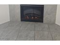 Close-up of a fireplace surrounded by stone tiles and gray tile floors at 8985 S Durango Dr # 1154, Las Vegas, NV 89113