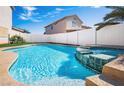 Inviting backyard pool and spa combination with mature plants and a white fence at 1011 Pearl Marble Ave, North Las Vegas, NV 89081