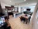 Open-concept kitchen featuring dark wood cabinets, granite counters, large island with seating, and tile flooring at 10383 Andele Ave, Las Vegas, NV 89166