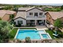 Aerial view of a backyard oasis with a sparkling pool, spa, patio, and lush landscaping at 11 Morninglow Pass, Henderson, NV 89052