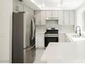 Modern kitchen with stainless steel appliances, granite countertops, and white cabinetry, ready for cooking at 111 Pomelo Ct, Henderson, NV 89074