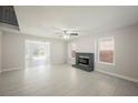 Bright living room featuring a brick fireplace, tile floors, and large windows for ample natural light at 111 Pomelo Ct, Henderson, NV 89074