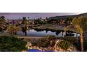 Stunning lake view from this property, complete with lush greenery, palm trees and mountain views at 11359 Winter Cottage Pl, Las Vegas, NV 89135