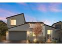 Modern two-story home with a two-car garage and a beautifully landscaped front yard at dusk at 14 Parco Fiore Ct, Henderson, NV 89011