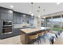 Gourmet kitchen with stainless appliances, granite countertops, and views of the backyard and mountains at 14 Parco Fiore Ct, Henderson, NV 89011