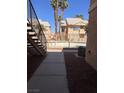 Condominium exterior view from a side angle, featuring landscaping and metal fence at 1830 N Pecos Rd # 155, Las Vegas, NV 89115