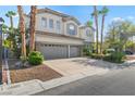 Two-story home featuring a three-car garage, stucco and brick exterior, and professionally landscaped front yard at 253 White Willow Ave, Las Vegas, NV 89123