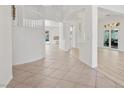 Bright foyer featuring tile flooring, an elegant curved staircase, and decorative columns at 253 White Willow Ave, Las Vegas, NV 89123