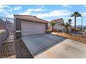 View of large driveway leading to a two-car garage with desert landscaping at 3443 Citruscedar Way, North Las Vegas, NV 89032