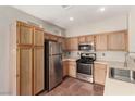 Bright kitchen features stainless steel appliances and oak cabinets offering ample storage at 4705 Delicate Arch Ct, North Las Vegas, NV 89031