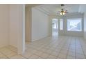 Bright living room featuring an open floor plan with large windows, white walls, and ceramic tile flooring at 494 Dart Brook Pl, Henderson, NV 89012