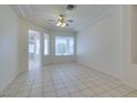 Bright living room featuring an open floor plan with large windows, white walls, and ceramic tile flooring at 494 Dart Brook Pl, Henderson, NV 89012