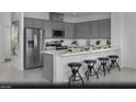 Modern kitchen with stainless steel appliances, gray cabinetry, a breakfast bar, and sleek countertops at 5761 Crenellated St # Lot 60, Las Vegas, NV 89148