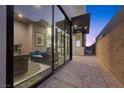 Modern patio with large sliding glass doors showcasing the living area, and stone pavers at 577 Overlook Rim Dr, Henderson, NV 89012