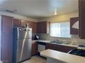 Classic kitchen featuring stainless steel refrigerator and range, and wood cabinets at 6086 Sunken River Trl, Las Vegas, NV 89118