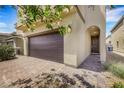 Home showing garage, front door, and brick paver driveway at 7011 Toll Mountain St, North Las Vegas, NV 89086
