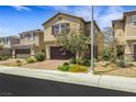 Two-story home showcases manicured desert landscaping, brick driveway, and attached garage at 7011 Toll Mountain St, North Las Vegas, NV 89086