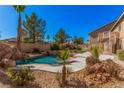 Backyard pool and spa with waterfall feature surrounded by lush landscaping at 8809 Barium Rock Ave, Las Vegas, NV 89143