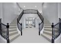 Grand staircase featuring dual curving staircases and black wrought iron railings at 8809 Barium Rock Ave, Las Vegas, NV 89143
