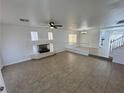 Spacious living room with tile flooring, fireplace, ceiling fan, and open floor plan at 10574 Salmon Leap St, Las Vegas, NV 89183