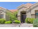 Inviting front entrance with double doors, decorative rock landscaping and manicured bushes at 10632 Clarion Ln, Las Vegas, NV 89134