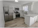 Bright kitchen features white cabinets, stainless steel appliances, a breakfast bar, and modern countertops at 134 Saint Albans Dr, Henderson, NV 89015