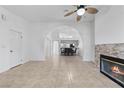 Open floor plan with tile flooring, arched doorway, and stone fireplace at 1411 Di Blasi Dr # 104, Las Vegas, NV 89119