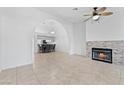Bright, open-concept living room features a stone fireplace and tile flooring at 1411 Di Blasi Dr # 104, Las Vegas, NV 89119