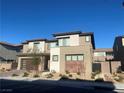 Two-story home with a modern design, desert landscaping, brick driveway, and an attached two-car garage at 201 Carmel Sky St, Las Vegas, NV 89138