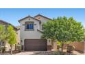 Charming two-story home featuring a brown garage door, stone accents, and manicured landscaping at 2276 Sky Island Dr, Henderson, NV 89002