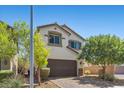 Charming two-story home featuring a brown garage door, stone accents, and manicured landscaping at 2276 Sky Island Dr, Henderson, NV 89002