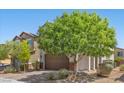 Charming two-story home featuring a brown garage door, stone accents, and manicured landscaping at 2276 Sky Island Dr, Henderson, NV 89002