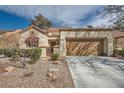 Inviting home with a two-car garage, decorative rock landscaping and a charming gated front entryway at 2520 Palmridge Dr, Las Vegas, NV 89134