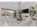 Bright living room with high ceilings, modern fireplace, comfortable white sofas, and views of the pool at 2601 Nevada Agave Ln, Las Vegas, NV 89138