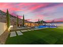 Wide angle view of a pool, spa and outdoor seating area featuring new stone walkway and turf at 2601 Nevada Agave Ln, Las Vegas, NV 89138