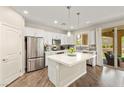 An open kitchen boasts stainless steel appliances, white cabinets, quartz countertops, and a sliding glass door to the patio at 419 Vigo Port St, Las Vegas, NV 89138