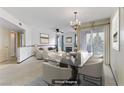Open-concept living and dining area with a fireplace, chandelier, and virtual staging at 4555 E Sahara Ave # 280, Las Vegas, NV 89104