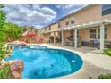 Resort-style backyard features a sparkling pool, spa, covered patio and lush landscaping at 5024 Granite Creek Ct, Las Vegas, NV 89131