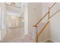 Bright foyer with tile flooring, a staircase with white railings, and an elegant chandelier, creating a welcoming entrance at 5128 Blissful Valley Cir, Las Vegas, NV 89149