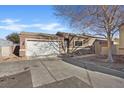 Charming single-story home with a wide driveway and a two-car garage under a blue sky at 5184 Mineral Lake Dr, Las Vegas, NV 89122